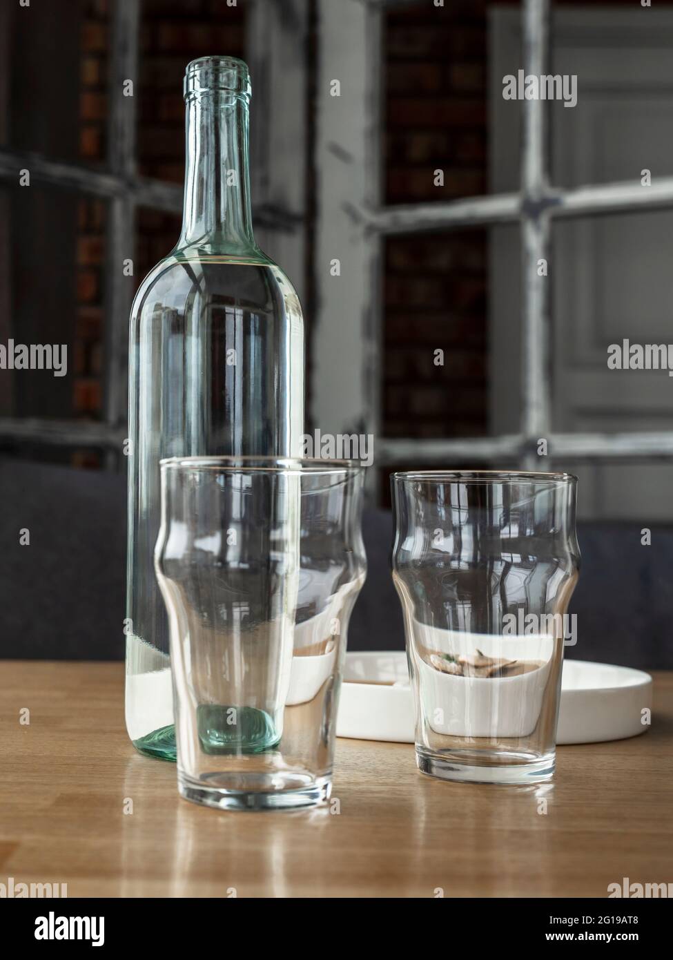Botella de vidrio transparente con agua o vino blanco y dos vasos de vidrio  vacíos Fotografía de stock - Alamy