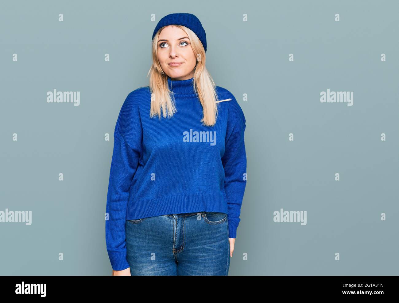 Joven mujer caucásica con suéter de invierno de lana y gorra sonriendo  mirando hacia un lado y mirando hacia fuera pensando Fotografía de stock -  Alamy