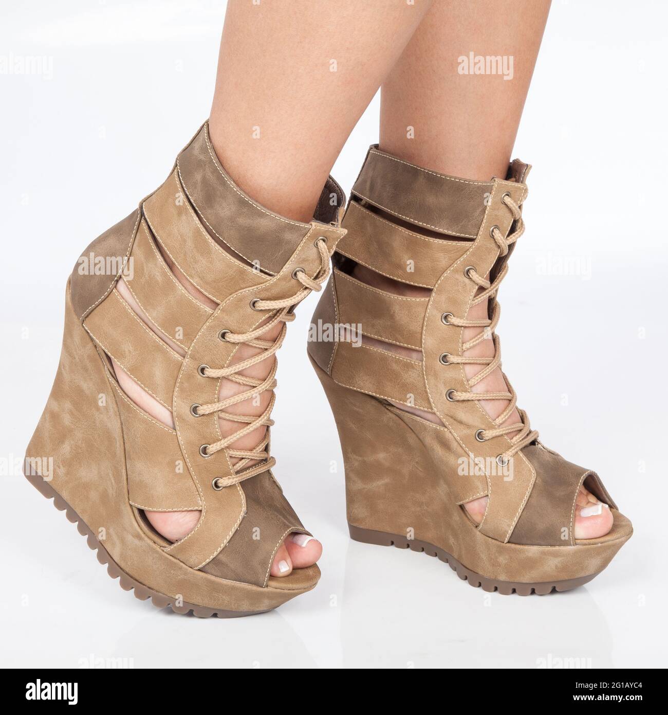 Zapatos de plataforma de cuero marrón en la bota con cordones beige que  ponen en los pies de la mujer sobre fondo blanco Fotografía de stock - Alamy
