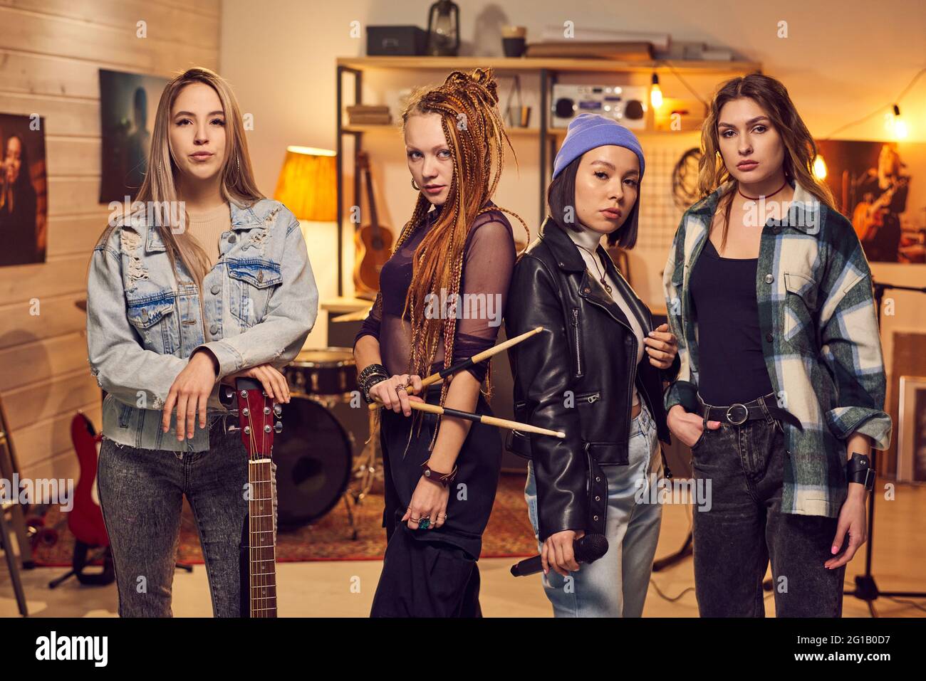 Banda de chicas que consta de cuatro mujeres de pie en fila en el estudio Foto de stock