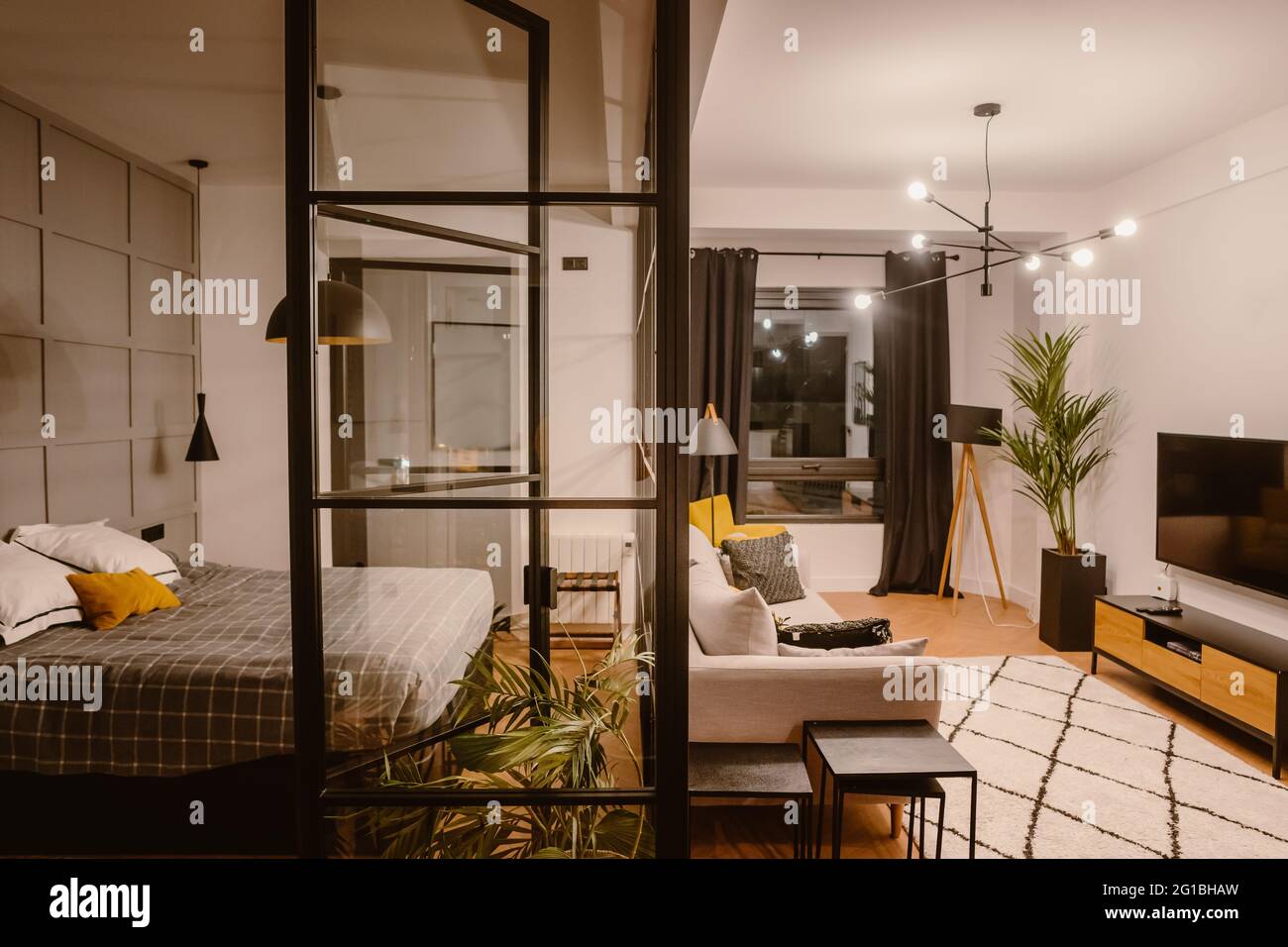 Interior de apartamento moderno con dormitorio con sala de estar separada  por la pared con sofá y TV Fotografía de stock - Alamy