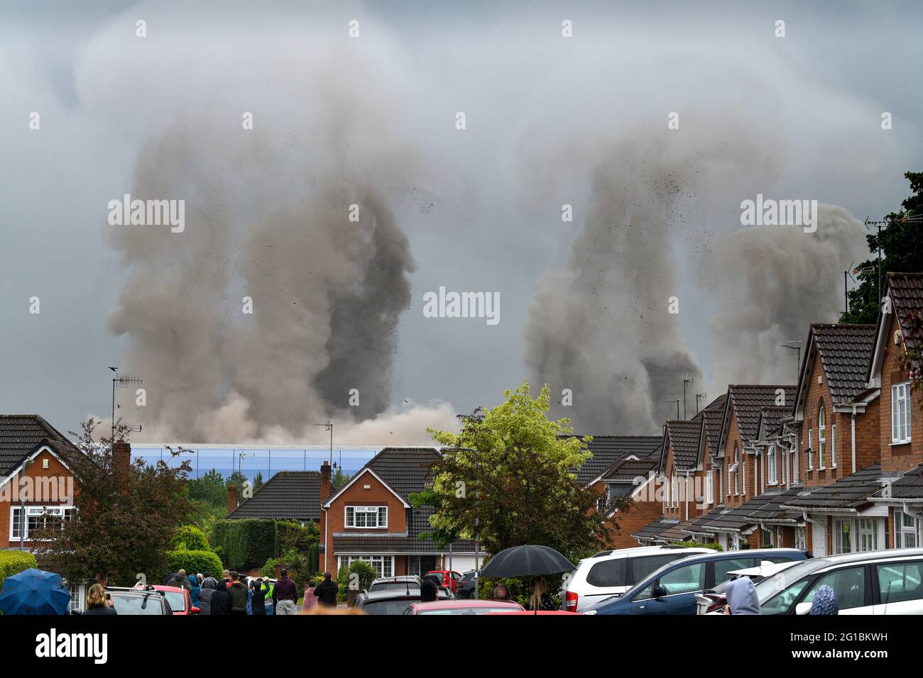 06 DE JUNIO DE 2021. RUGELEY, STAFFORDSHIRE. Reino Unido Las torres de refrigeración de la central eléctrica de Rugeley son bajadas por una explosión controlada en torno a las 11:30am de hoy. La central eléctrica de carbón, una de las pocas que quedan y conocida como la central eléctrica Rugeley B, había formado parte del horizonte urbano desde 1970 y fue cerrada en 2016. Generó suficiente electricidad para alimentar alrededor de medio millón de hogares. Vista desde una finca cercana. Foto de stock