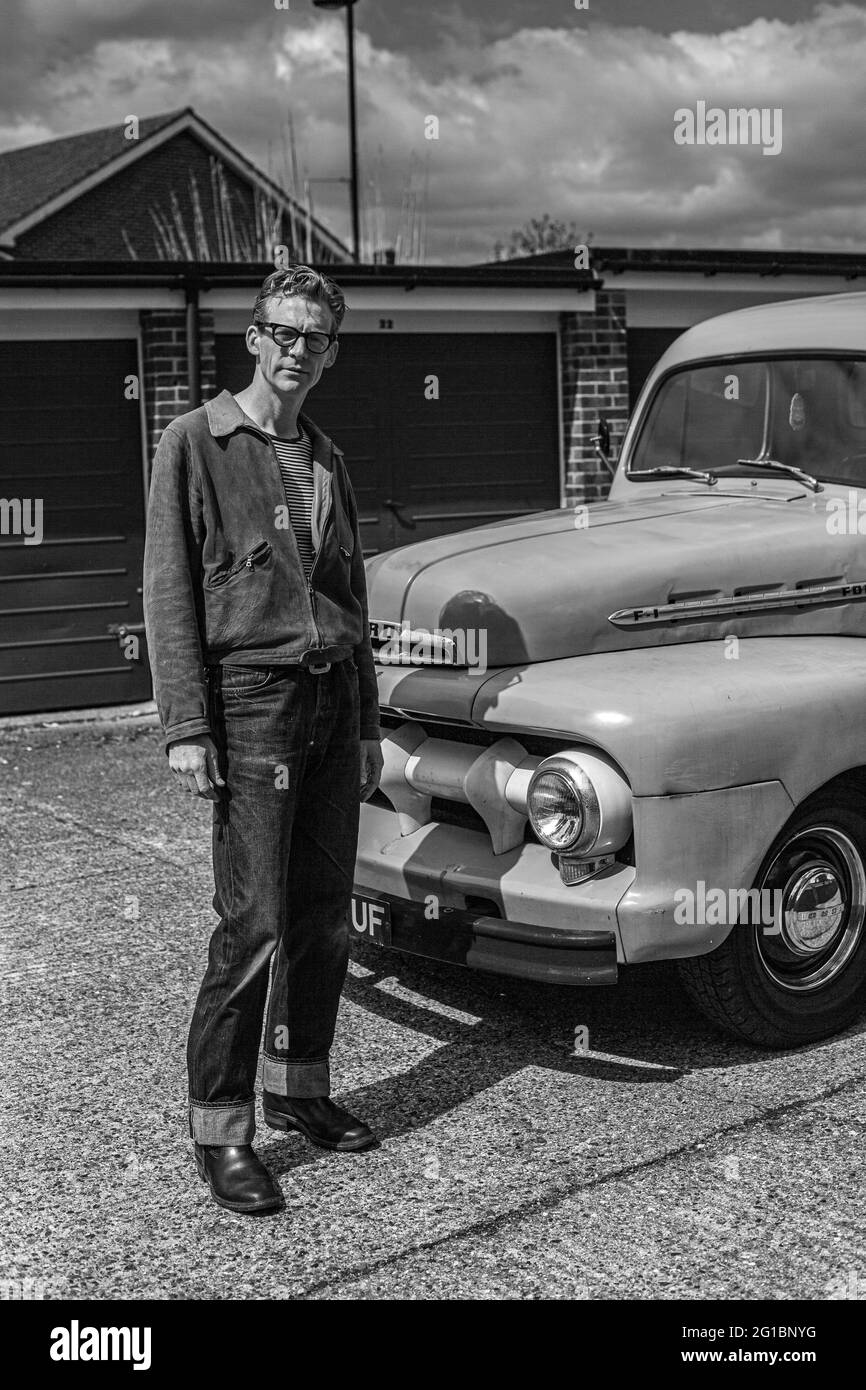 Hombre con vaqueros de pie en frente de su camión Ford F 1 pick-up. Foto de stock