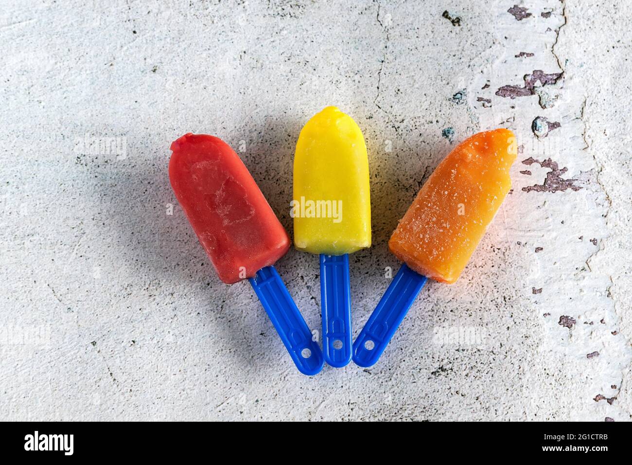 Tres mini helados de colores sobre fondo blanco Foto de stock