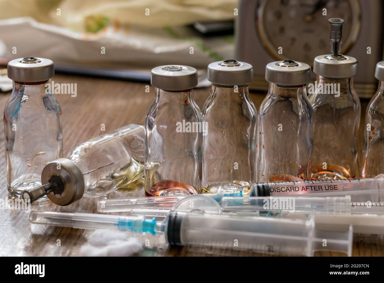 jeringas después de inyecciones y frascos de medicina en la mesa Foto de stock