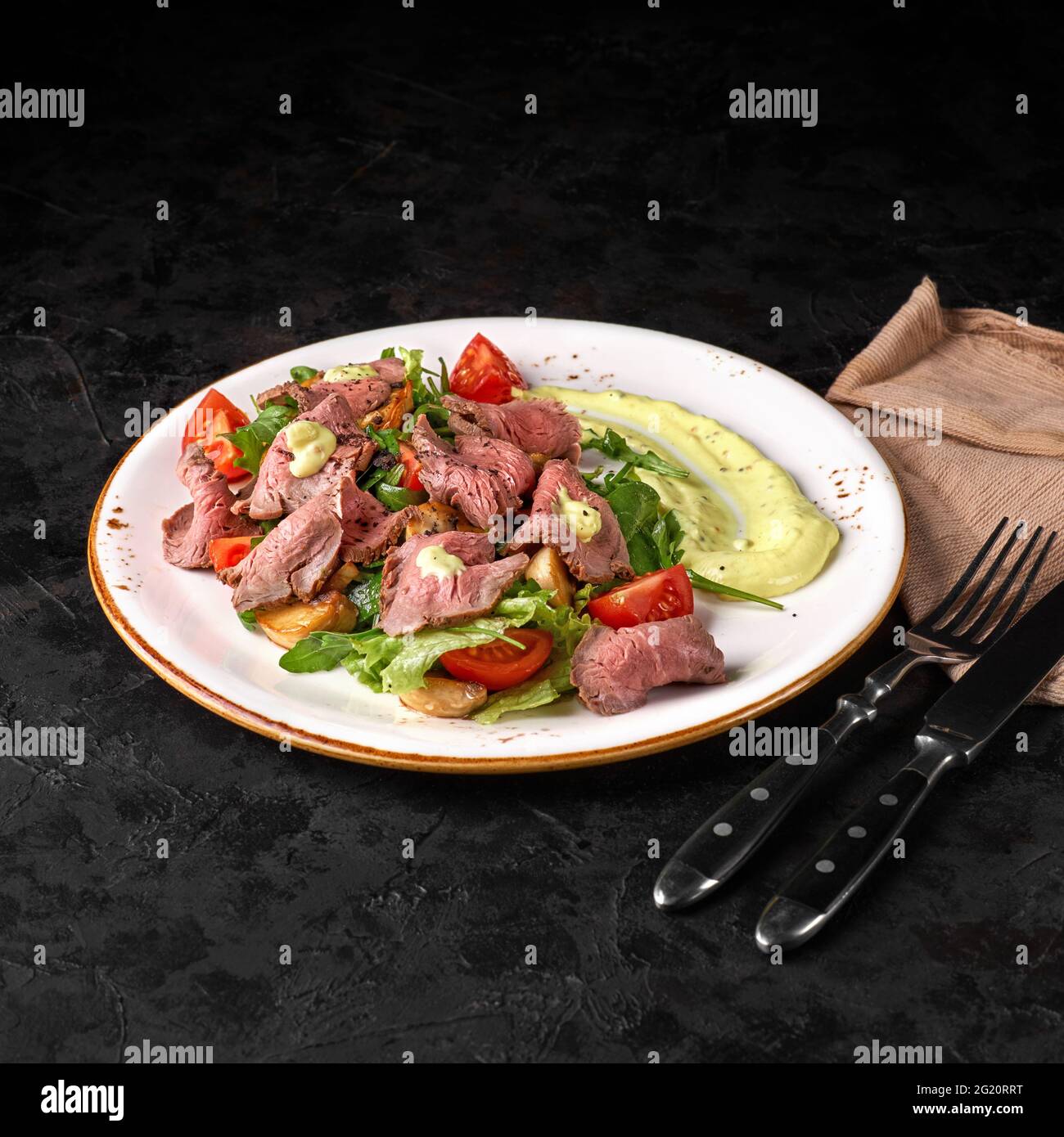Patatas, bistec de ternera, ensalada romana y vegetal sobre un fondo de madera, vista superior. Dieta equilibrada alimentos saludables sobre fondo negro. Aperitivo o merienda Foto de stock