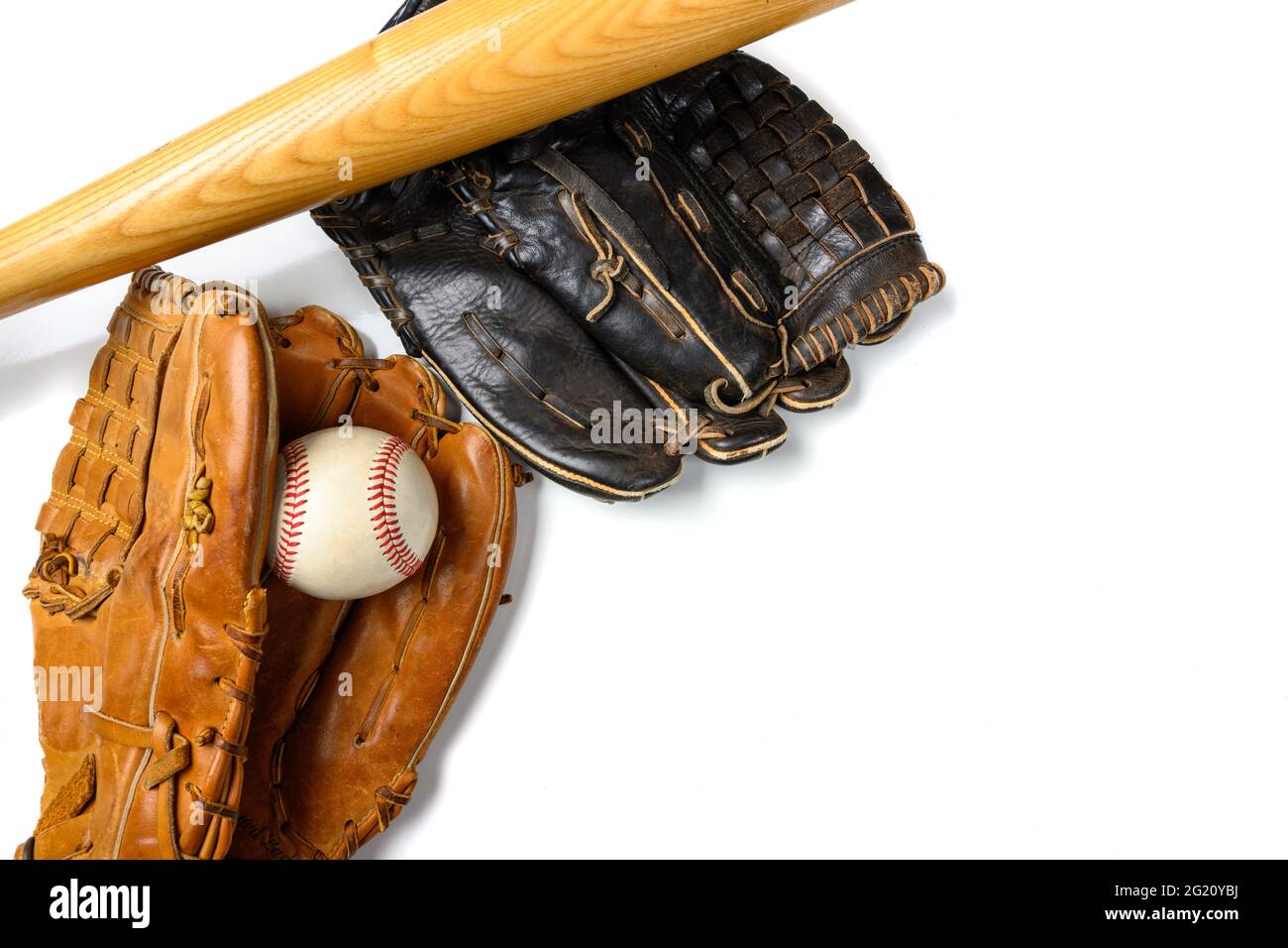 Guantes de béisbol de cuero con una pelota y un murciélago sobre blanco Foto de stock