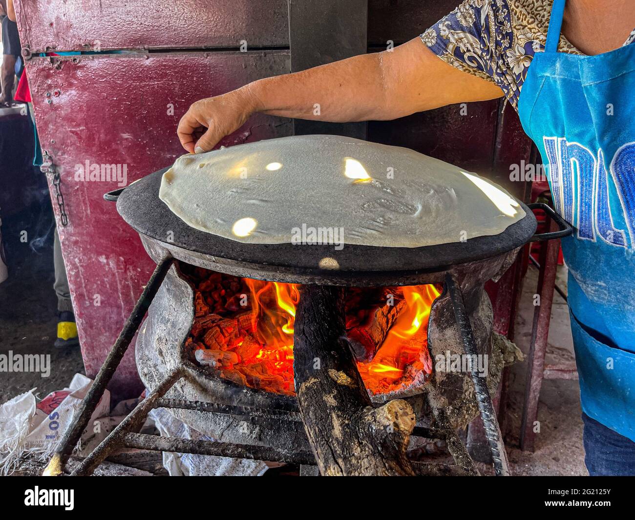 Tortillas de harina cocinadas en un comal de acero con el fuego de las