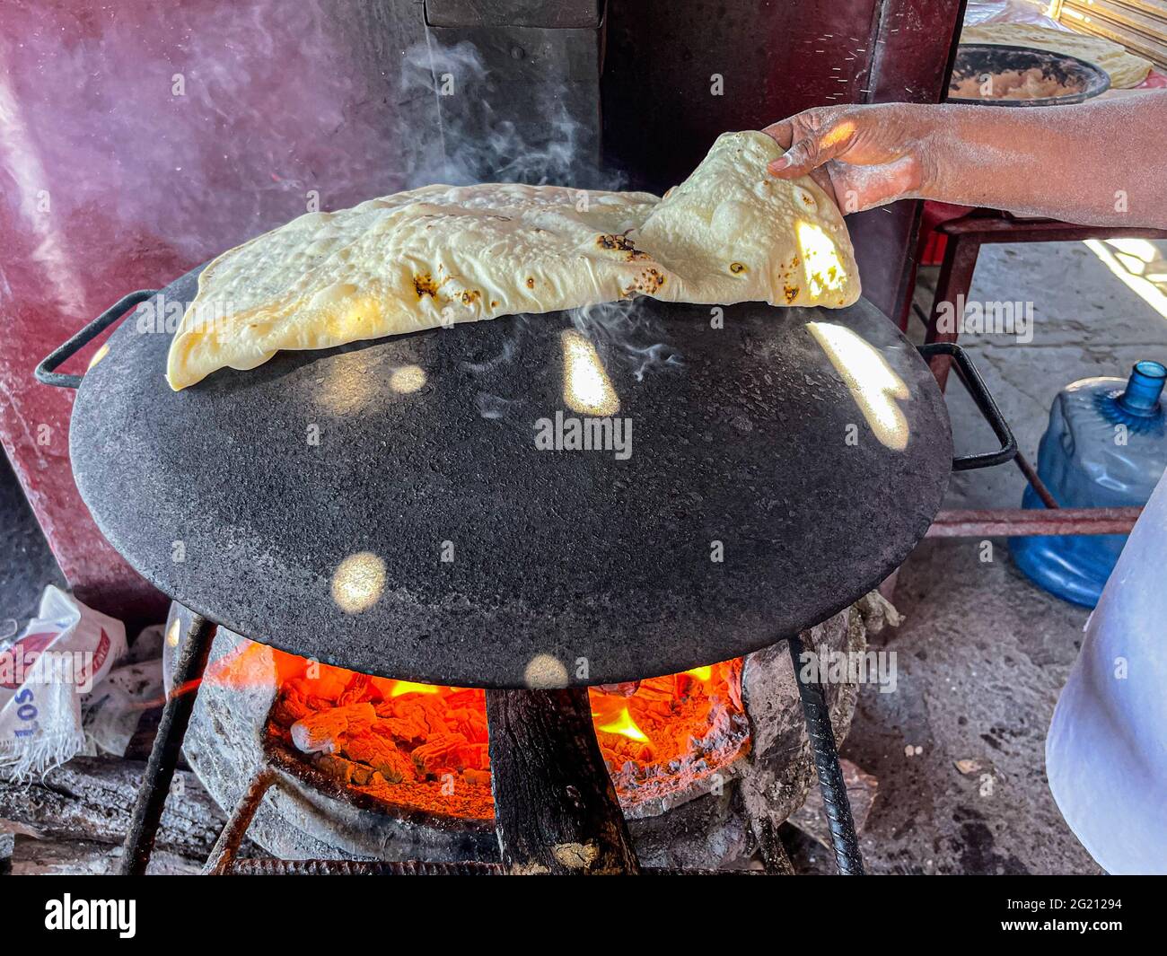 Tortillas de harina cocinadas en un comal de acero con el fuego de las