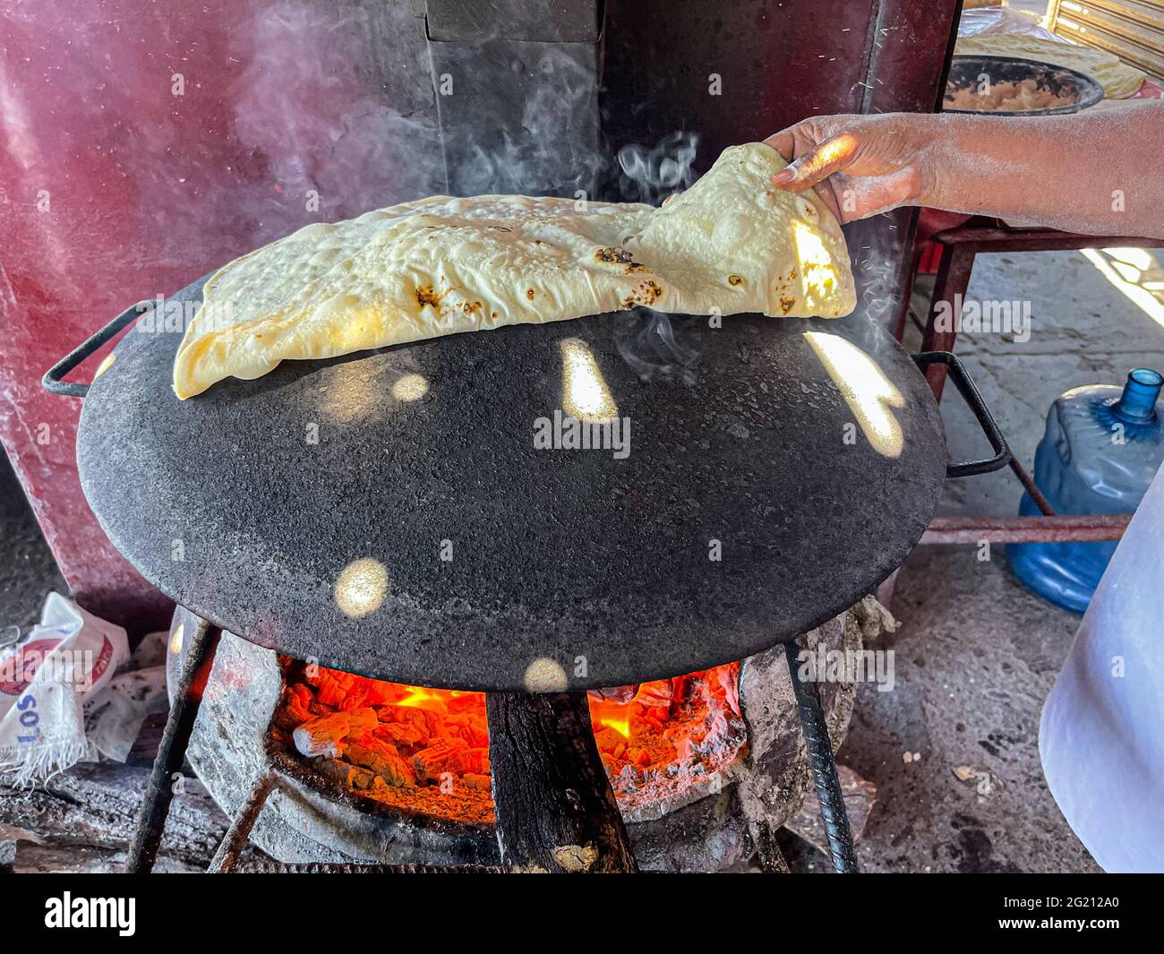 Tortillas de harina cocinadas en un comal de acero con el fuego de las