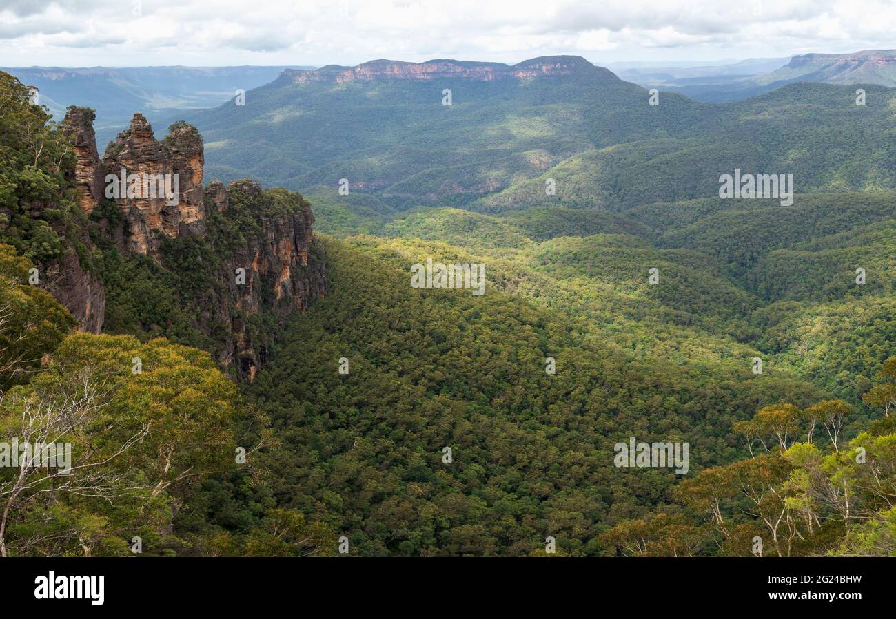 Australia, Nueva Gales del Sur, formación rocosa de tres hermanas con Mount Solitary y Jamison Valley en el Parque Nacional Blue Mountains visto desde Echo Point Lookout Foto de stock