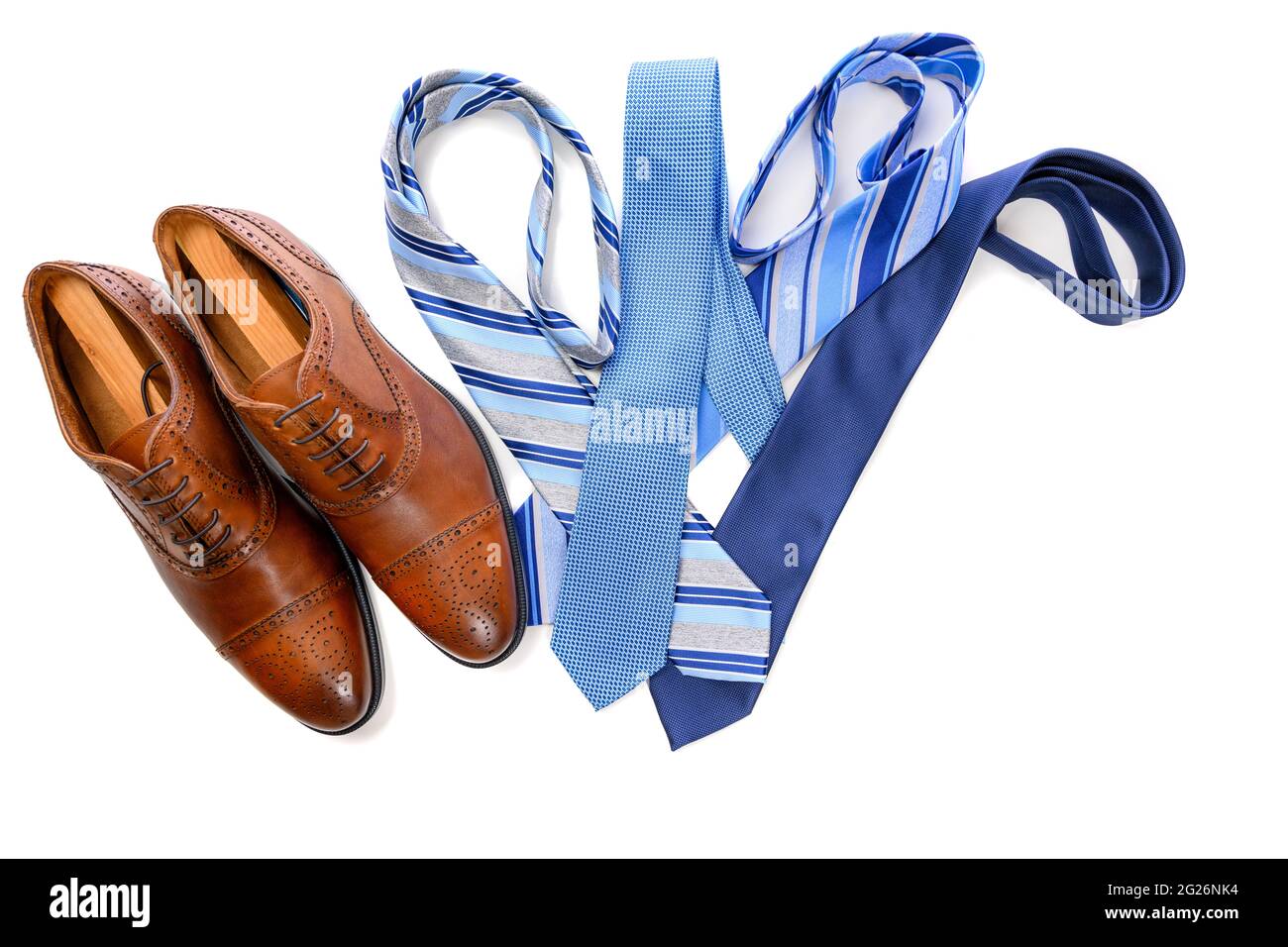 Un par de zapatos de vestir marrones con corbatas azules sobre fondo blanco Foto de stock