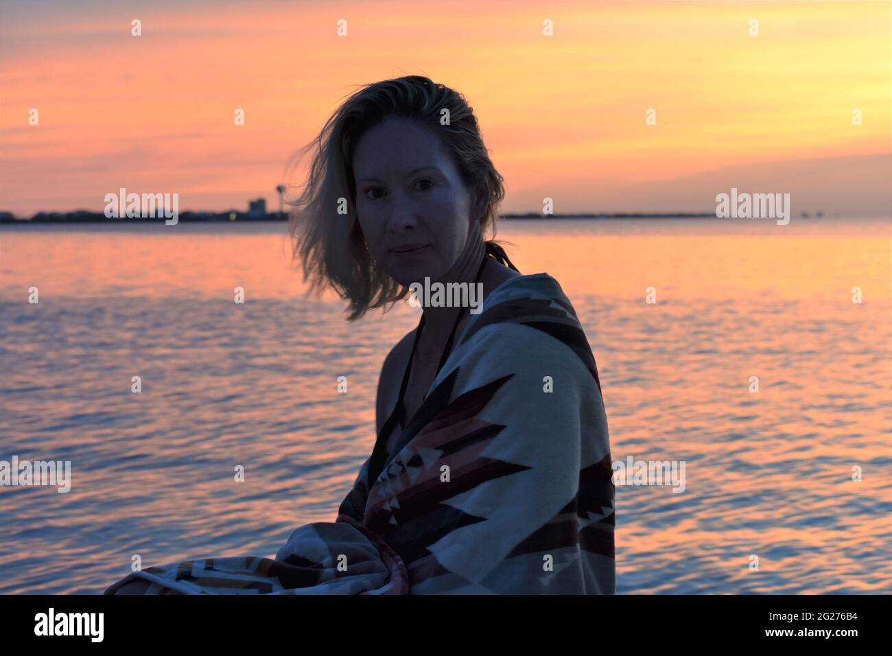 Mujer en la playa durante la puesta de sol Foto de stock