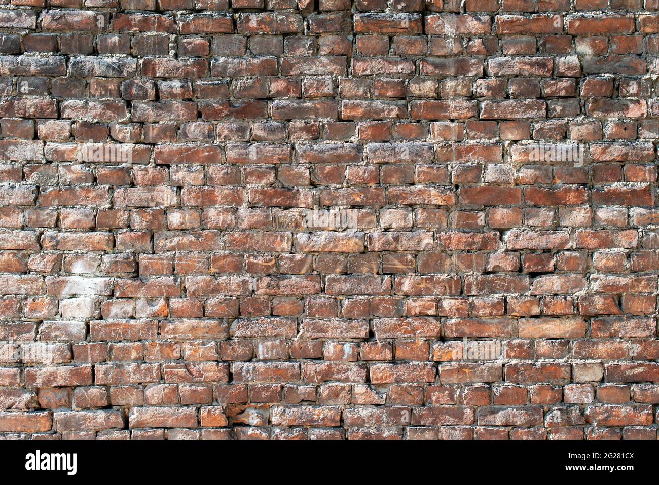 Pared de ladrillo antiguo con partes abultadas como fondo. Foto de stock