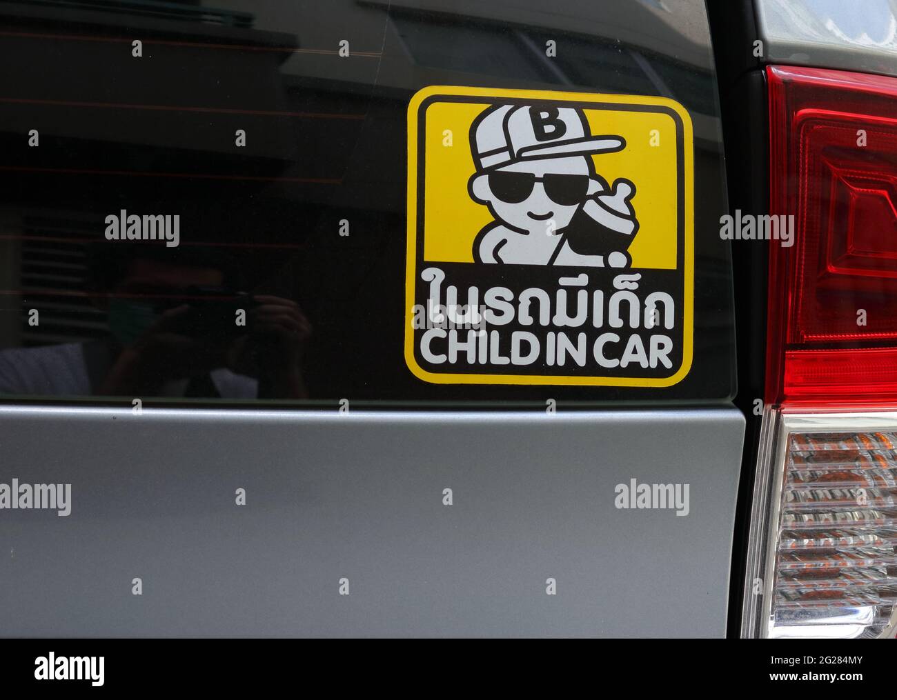 Bangkok, Tailandia - 7 de junio de 2021 : Etiqueta adhesiva de primer plano con dibujos animados y mensaje niño en el coche unido al parabrisas trasero de un coche Foto de stock