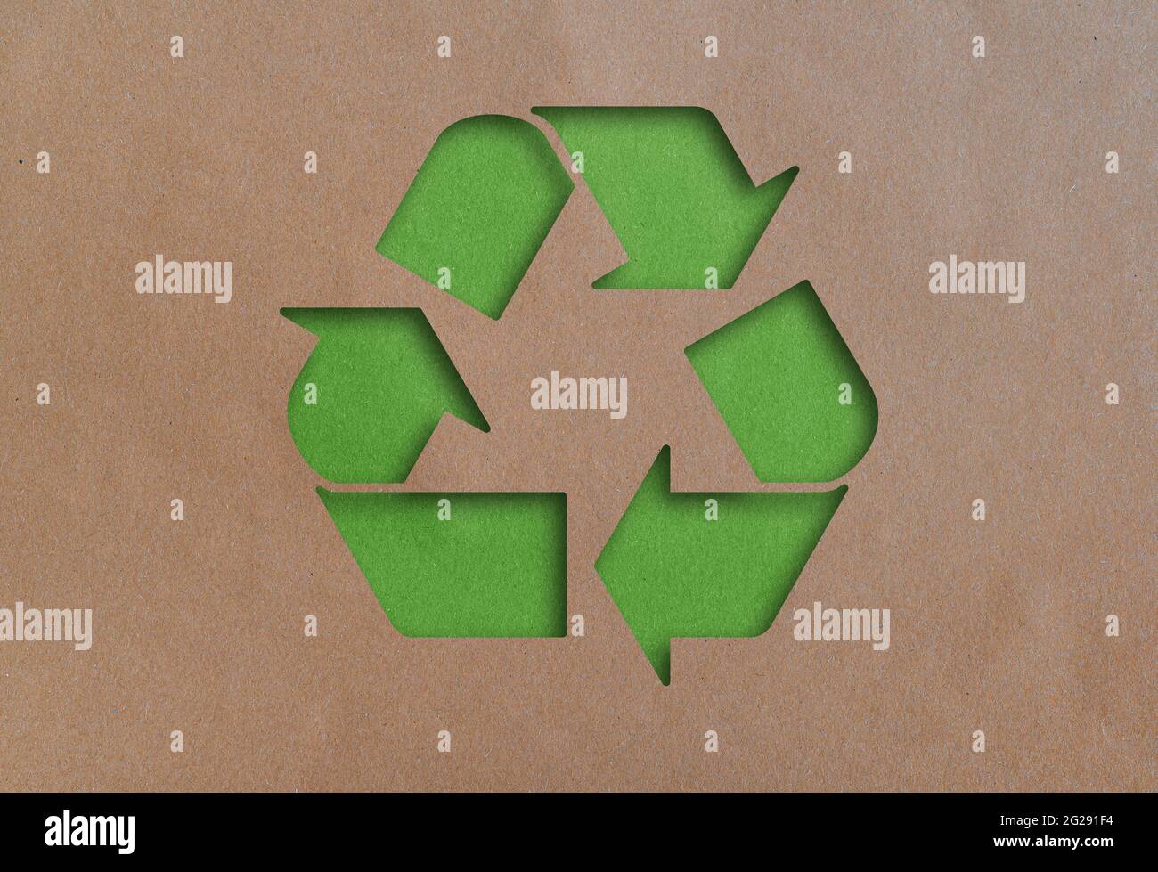 símbolo de reciclaje cortado en papel reciclado marrón Foto de stock