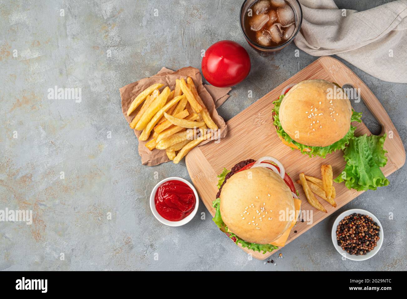 Hamburguesas, papas fritas y cola sobre fondo gris. Comida rápida. Vista  superior, espacio de copia Fotografía de stock - Alamy