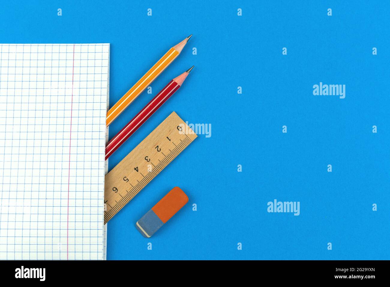 Prepárese para la composición del concepto de los primeros días escolares, fondo azul plano con cuaderno, lápiz, regla de madera y borrador, copia espacio vista superior ph Foto de stock