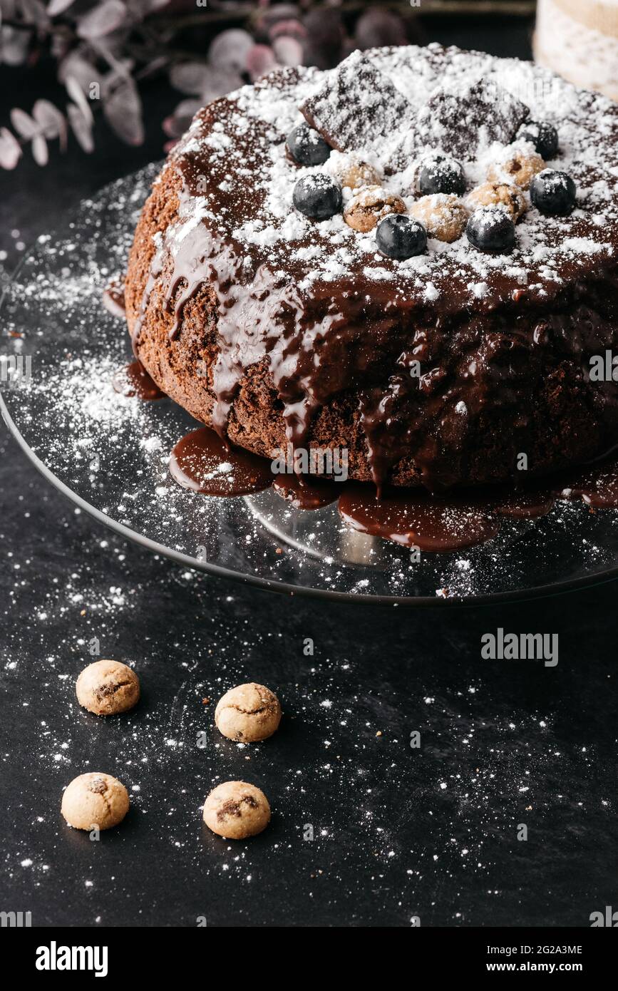 Desde arriba de deliciosa torta de chocolate con espuma de chocolate y  decorado con azúcar en polvo y dulces servidos en una mesa de cristal con  botellero Fotografía de stock - Alamy