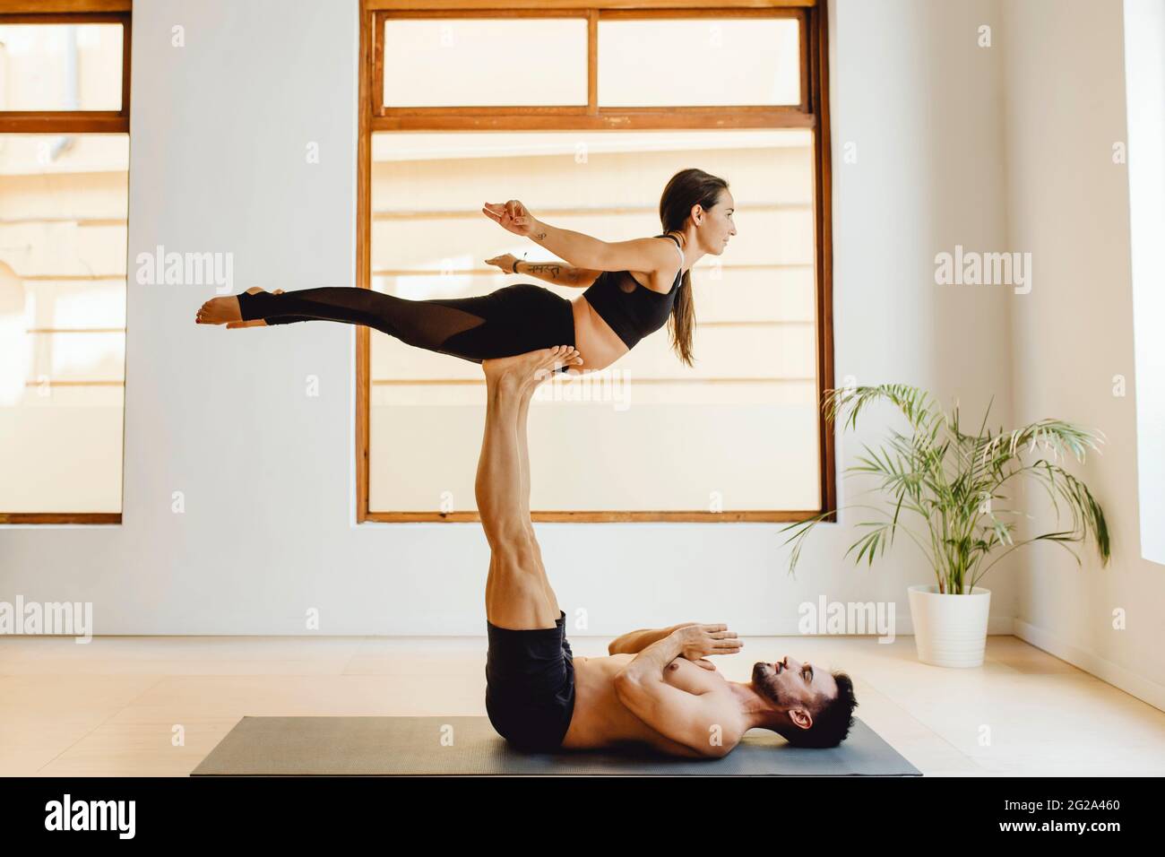 pareja haciendo una posición de equilibrio en una sesión de yoga en la sala  de entrenamiento Fotografía de stock - Alamy
