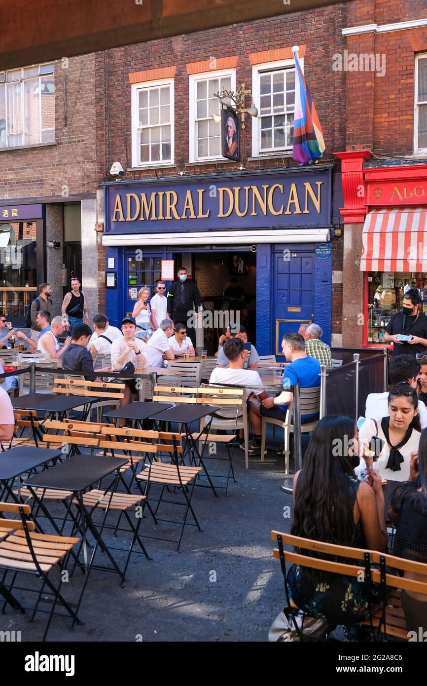 Los visitantes de West End disfrutan de un cálido día de verano durante el levantamiento de las restricciones de la pandemia de Covid-19, Old Comton Street, Londres, Reino Unido Foto de stock