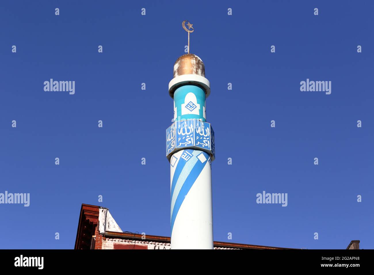 Una media luna y un alem estrella adornan la cima de un minarete en la mezquita Madina Masjid en el barrio East Village de Manhattan en la ciudad de Nueva York. Foto de stock