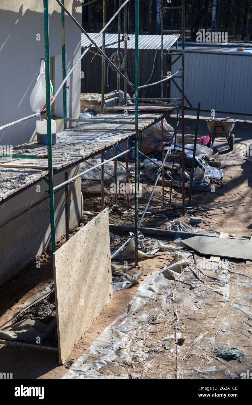 Andamios y un patio sucio con escombros de construcción iluminados por la  luz del sol Fotografía de stock - Alamy