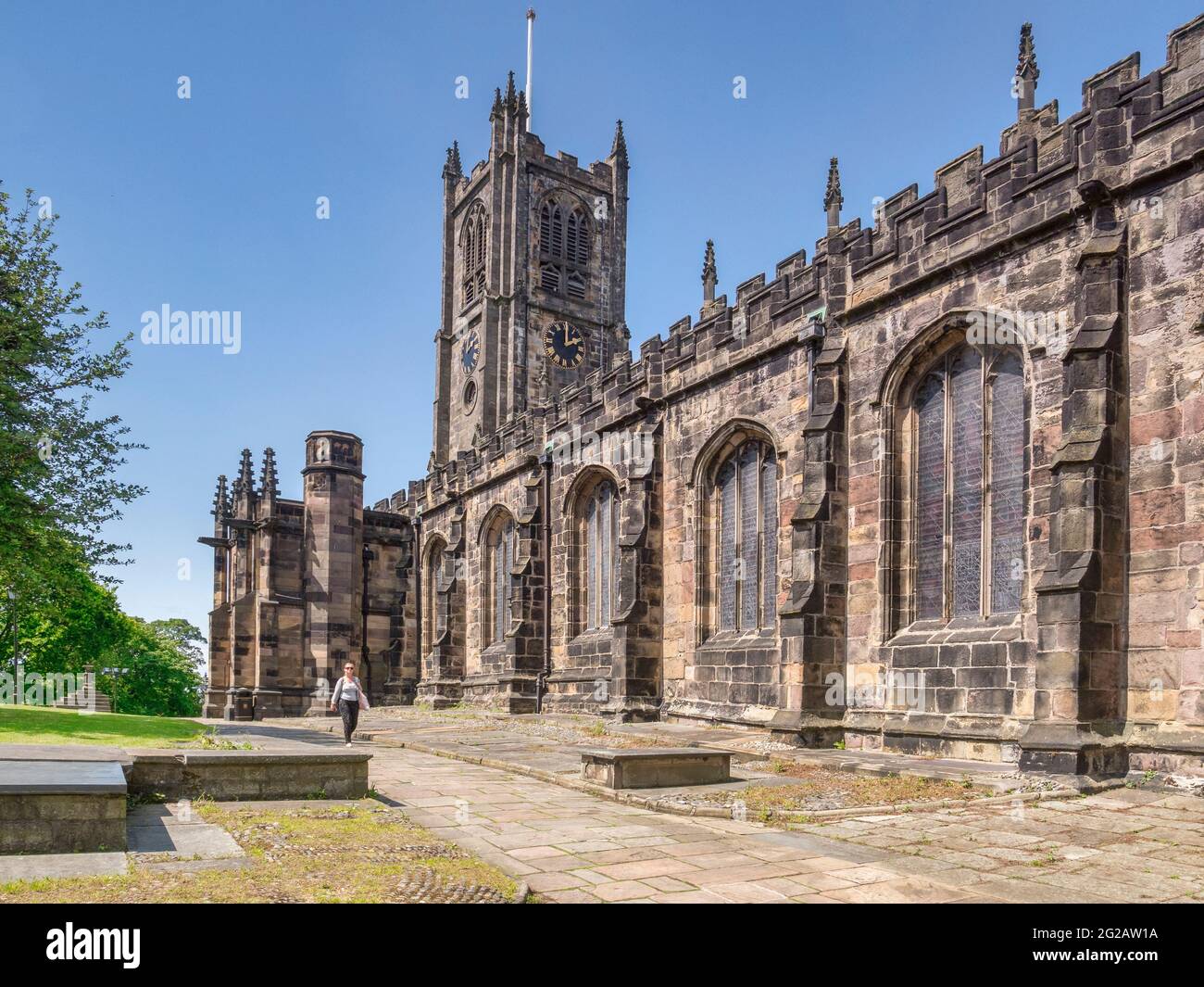 12 de julio de 2020: Lancaster, Reino Unido - La Iglesia del Priorato de Santa María en verano, la mujer caminando. Foto de stock