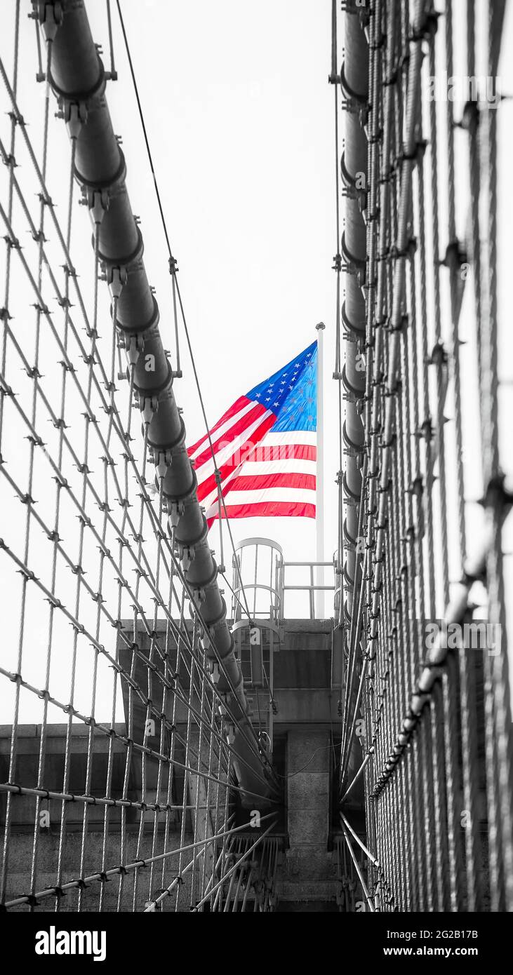 Bandera estadounidense en la parte superior del Puente de Brooklyn, tonificación de color aplicada, Nueva York, EE.UU. Foto de stock
