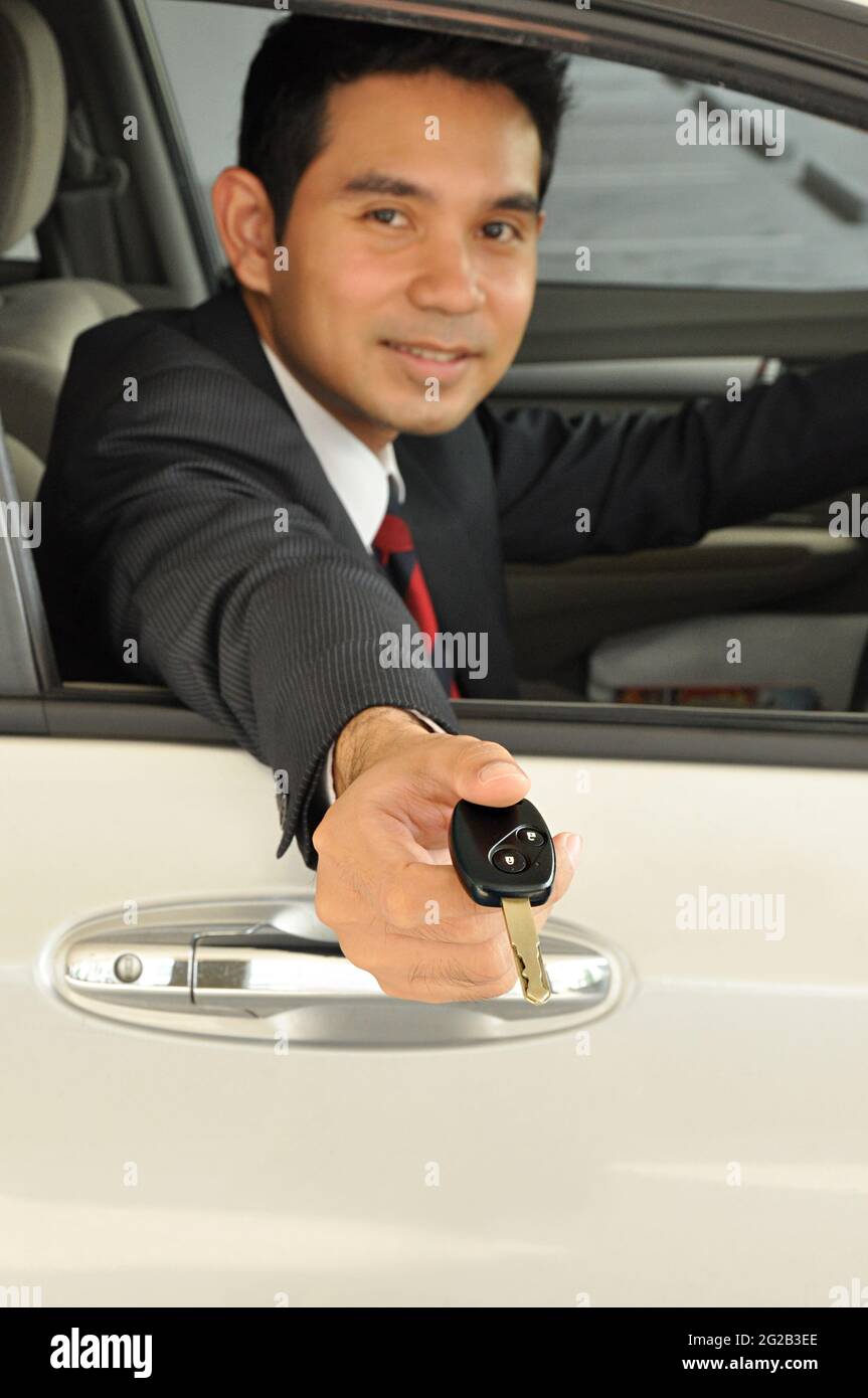 hombre de negocios que da la llave del coche Foto de stock