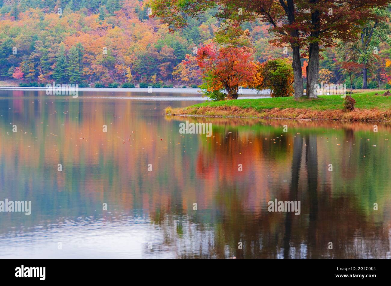 Lago tranquilo que refleja el follaje otoñal en las montañas Blue Ridge, cadena Appalachia, EE.UU. Foto de stock