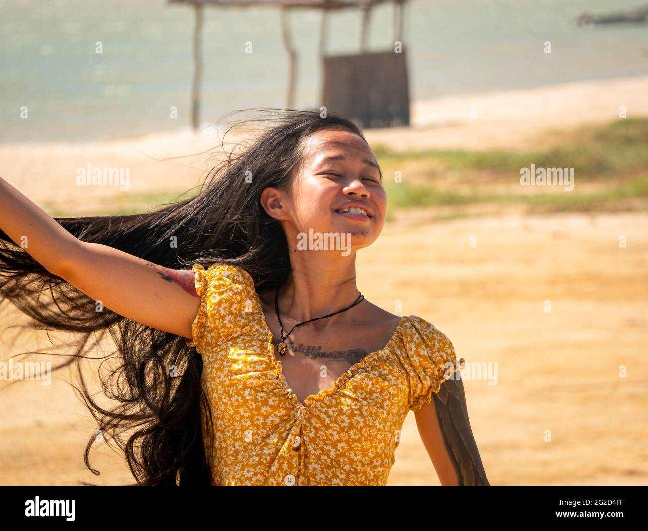 Bahia Honda, La Guajira, Colombia - 27 2021 de mayo: Mujer asiática joven de Indonesia bailando felizmente en el desierto junto al mar Foto de stock