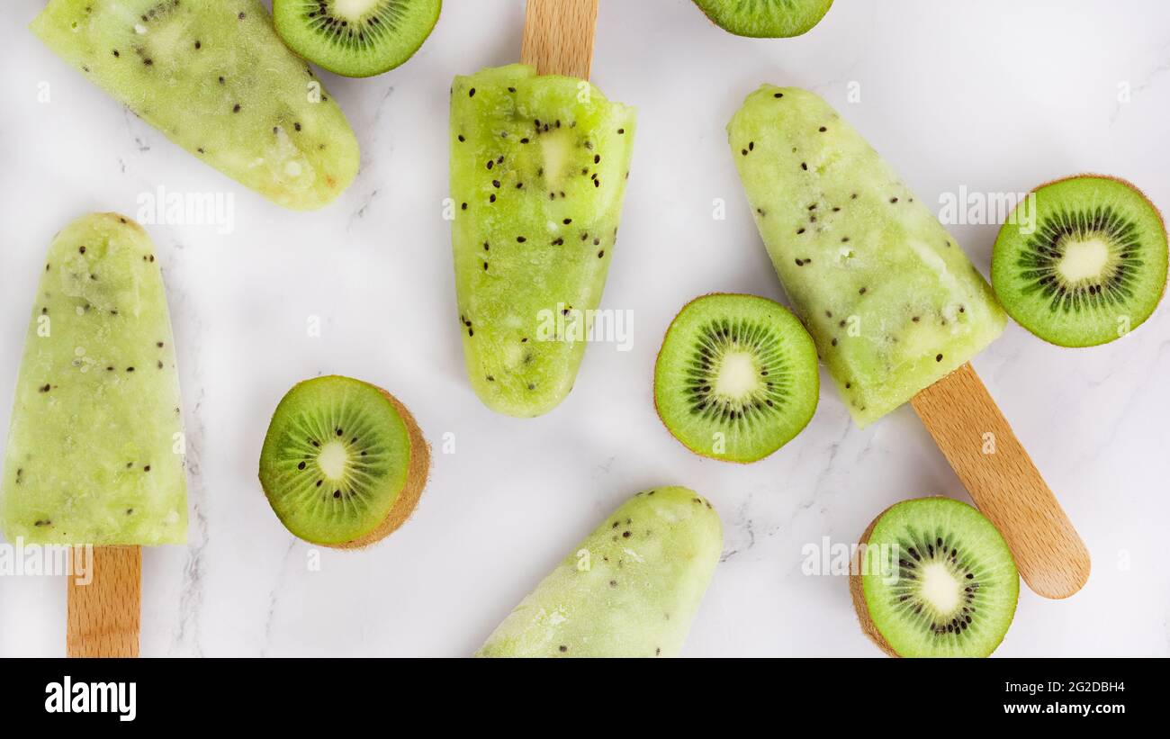 Zumo de kiwi de fruta congelado. Paleta en un palo y kiwi. Patrón  Fotografía de stock - Alamy