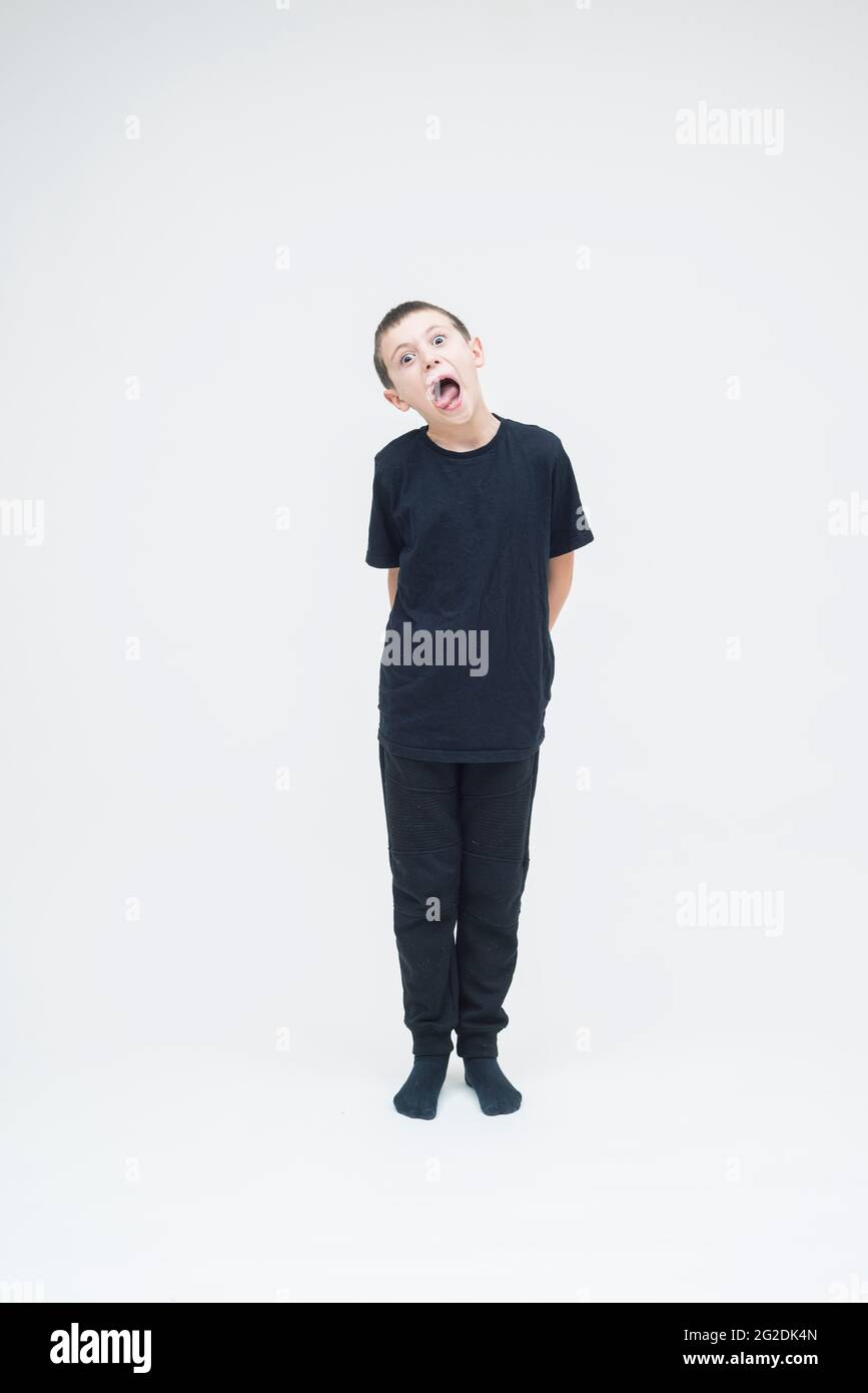 Un niño está de pie sobre un fondo blanco sin costuras con toda la ropa  negra Fotografía de stock - Alamy