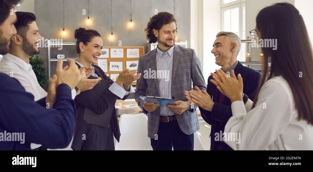 Equipo de gente de negocios agradecida aplaudiendo a un orador por su presentación en una reunión Foto de stock