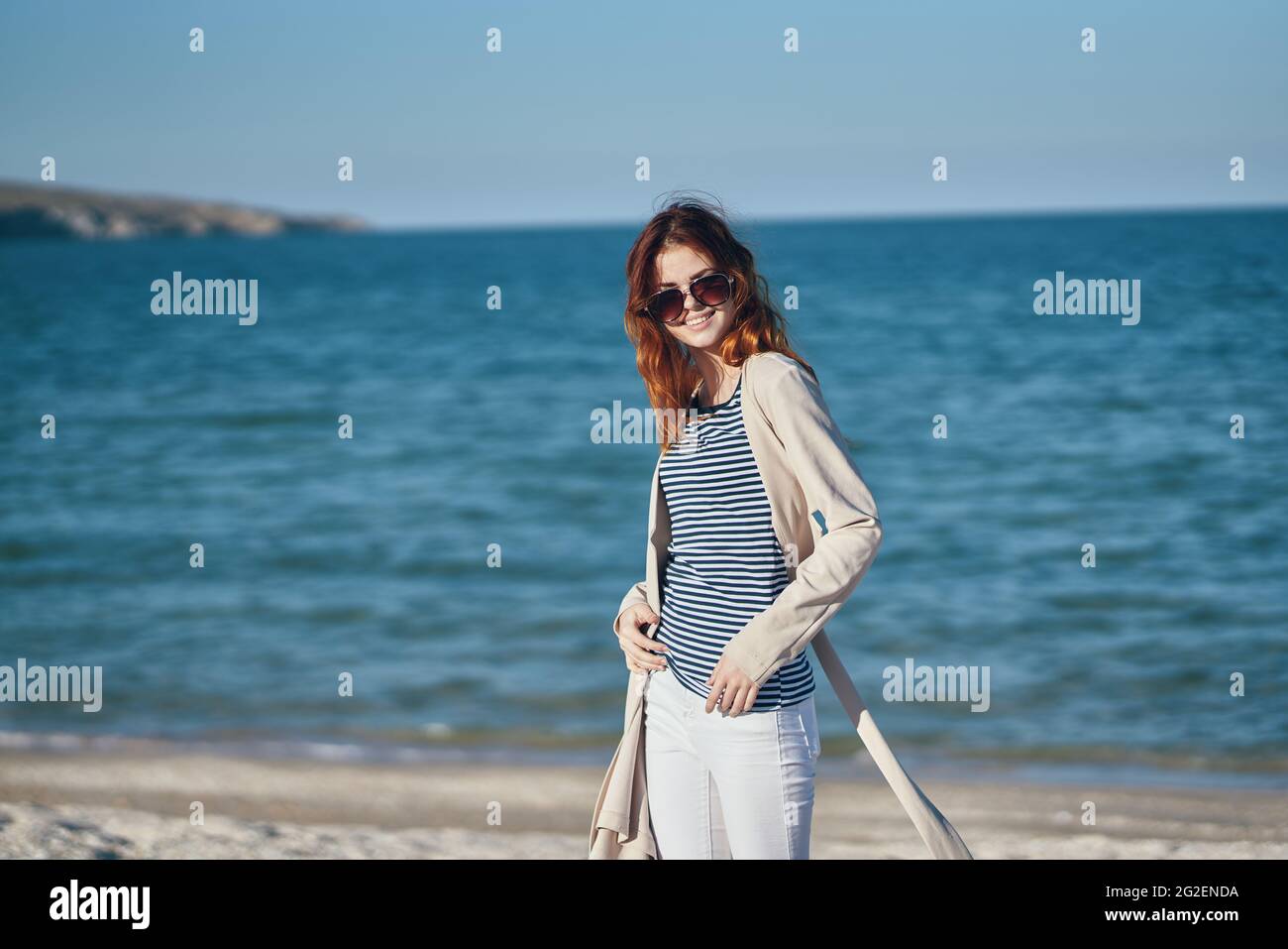 una mujer en una camiseta y un pantalón de suéter corre a lo largo de la  playa en verano en las montañas en la naturaleza Fotografía de stock - Alamy