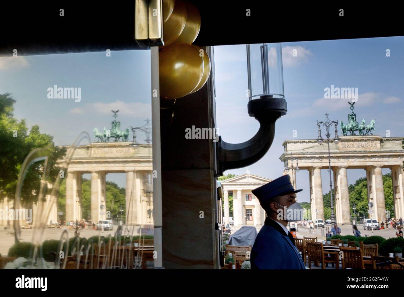 Berlín, Alemania. 11th de junio de 2021. Hay un botones bajo globos dorados  frente a la entrada del hotel del Hotel Adlon Kempinski en Pariser Platz,  cerca de la Puerta de Brandenburgo.