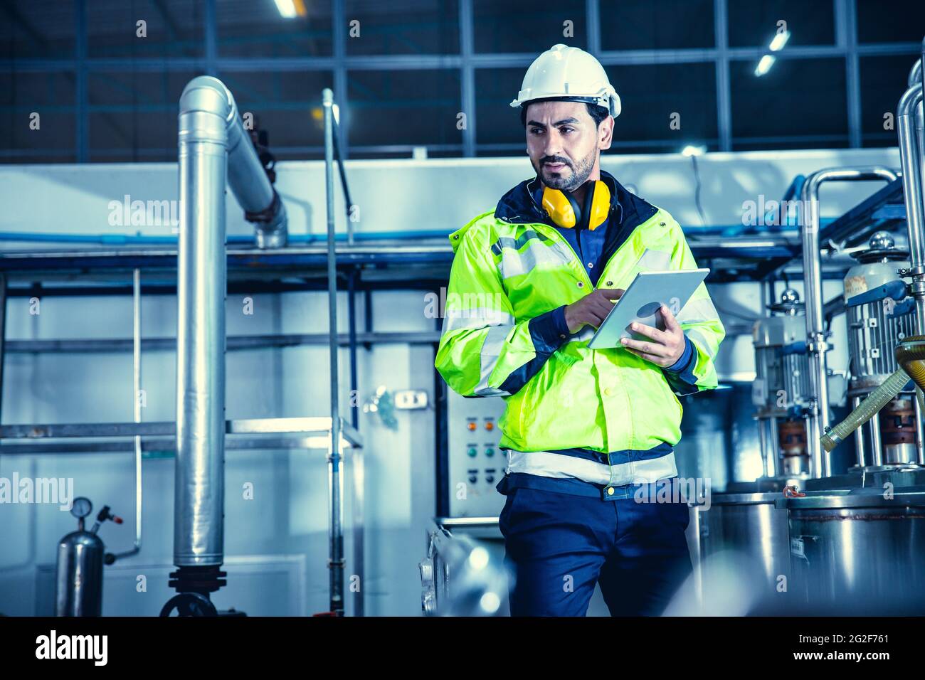 Ingeniero de trabajo de fábrica que trabaja en fábrica utilizando un tablet ordenador para comprobar el mantenimiento de la tubería de agua de la caldera en la fábrica. Foto de stock