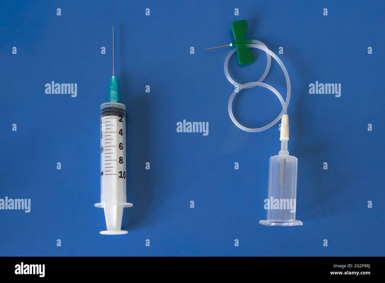 Comparación entre jeringa clásica y vacutainer moderno con aguja de mariposa.  Aislado sobre fondo azul Fotografía de stock - Alamy