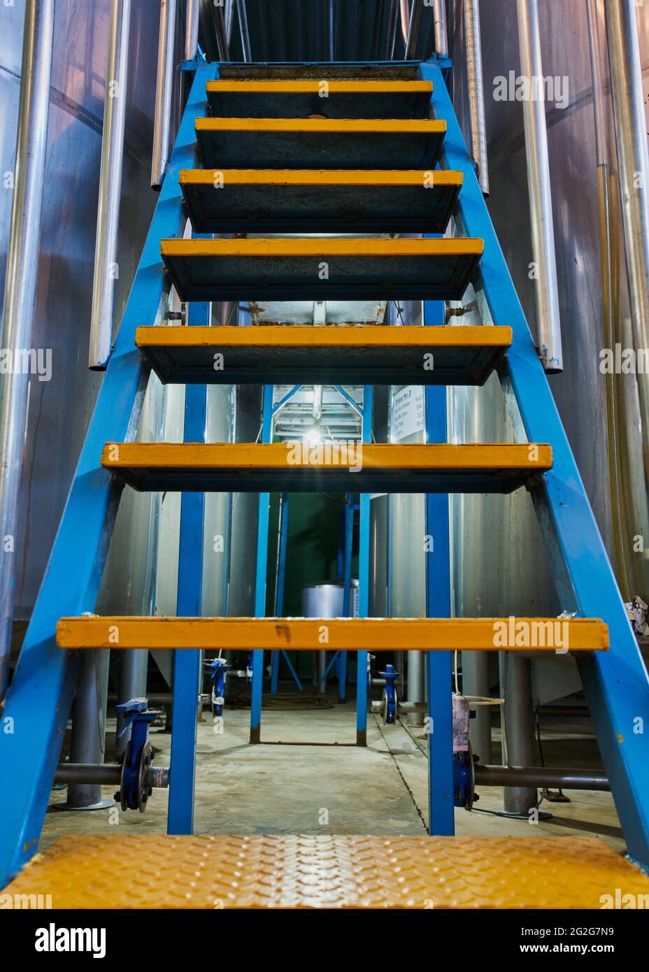 Escalera industrial de metal azul y amarillo para una fábrica de tequila Foto de stock