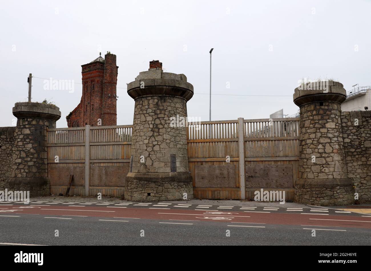 Torre del acumulador hidráulico de ladrillo y pared fronteriza en Bramley Moore Dock en Liverpool Foto de stock