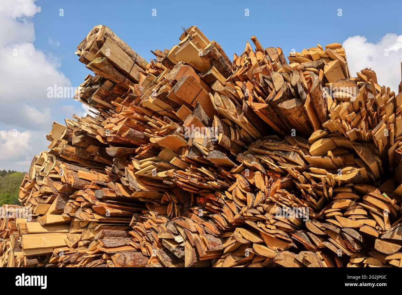 Solingen, Renania del Norte-Westfalia, Alemania - La madera residual en el almacén de madera de un aserradero se procesa en astillas de madera y se utiliza como combustible en la central térmica, la madera es escasa y cara, carpinteros y fábricas de madera están luchando con el rápido aumento de los precios de la madera cruda en tiempos de la crisis de la corona, Grandes cantidades de madera de tronco van a la exportación a China y Estados Unidos. Foto de stock