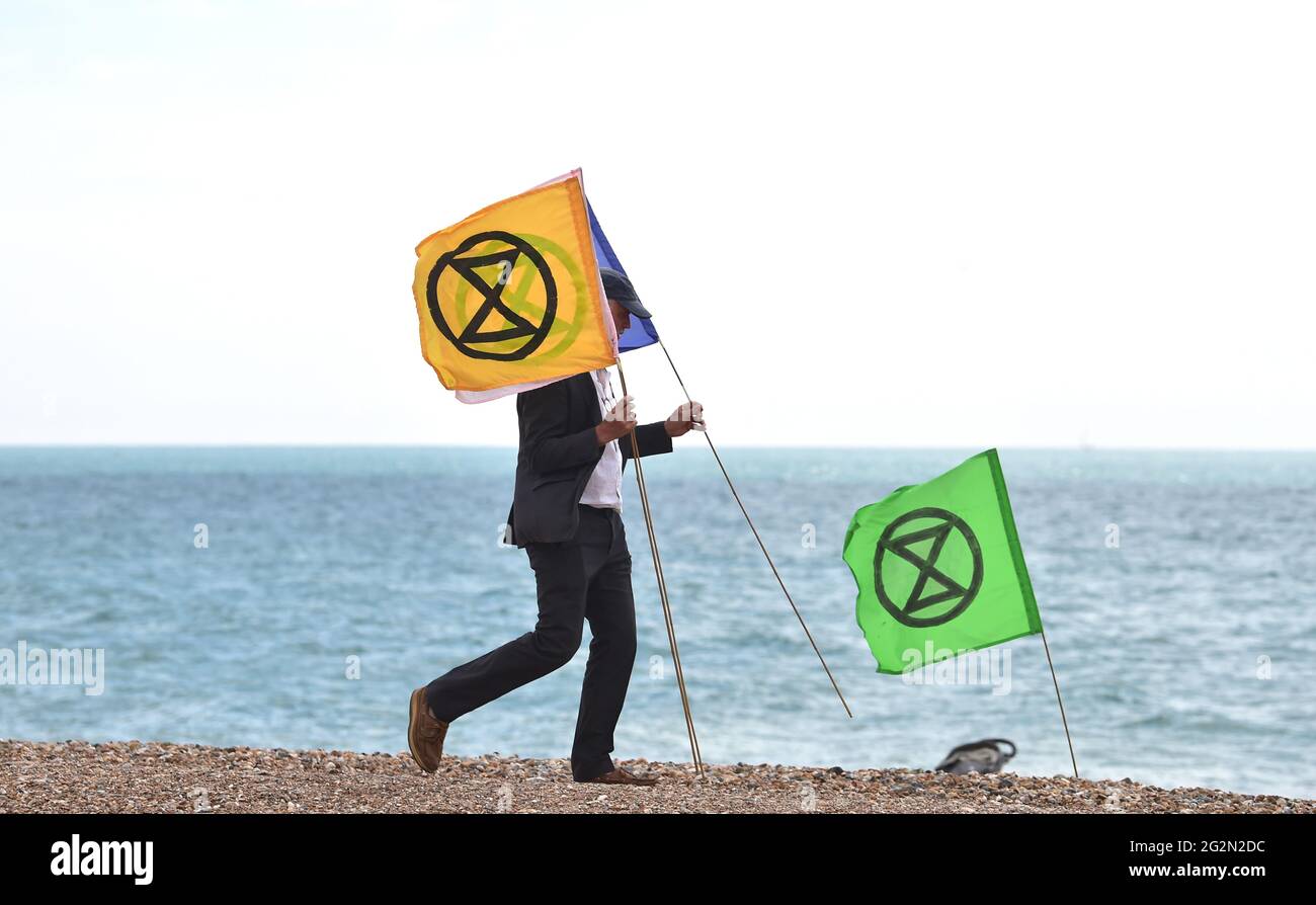 Worthing Sussex UK 12th de junio de 2021 - Activistas de Extinción Rebellion participa hoy en protesta en Worthing Beach como parte de un fin de semana de acción para coincidir con la cumbre de G7 y destacar los efectos del cambio climático y el aumento del nivel del mar : Crédito Simon Dack / Alamy Live News Foto de stock