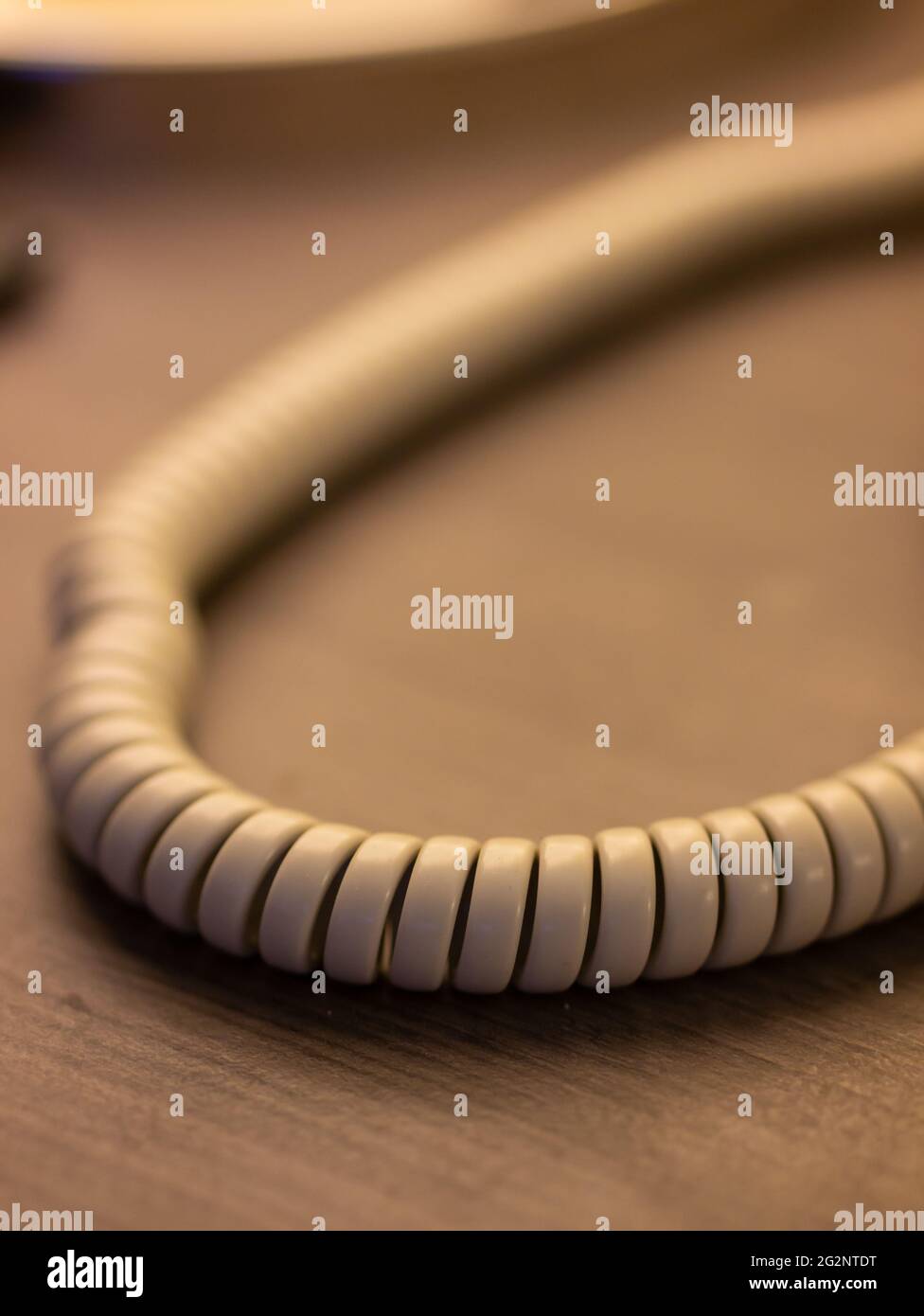 primer plano del cable blanco de espiral curvo sencillo. Línea telefónica. Conexión de larga distancia. Tecnologías para mantenerse en contacto. Foto de stock
