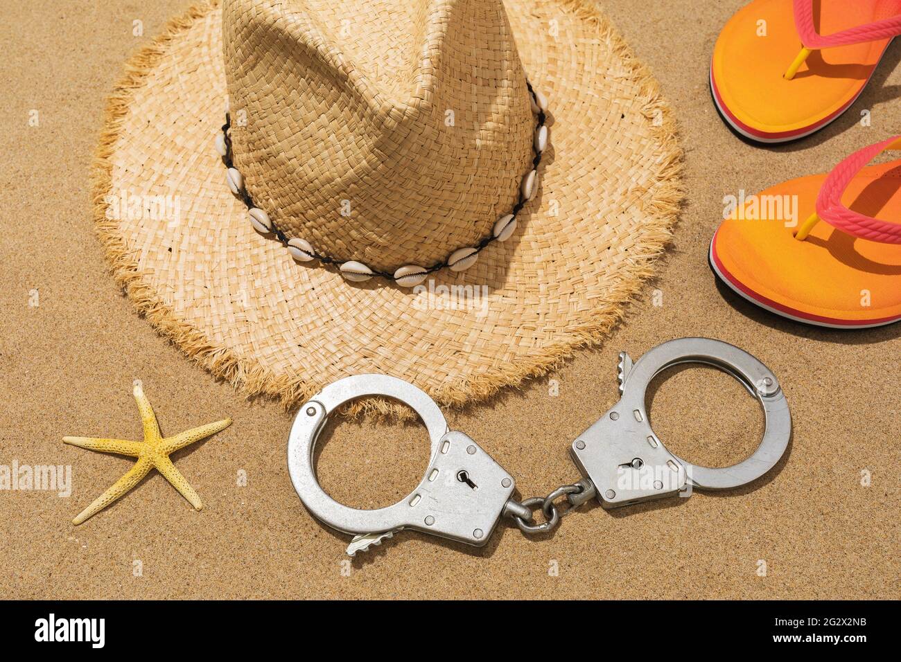 Esposas, sombrero, zapatillas y estrellas de mar en la arena, concepto  sobre el tema del castigo por robo en la playa Fotografía de stock - Alamy