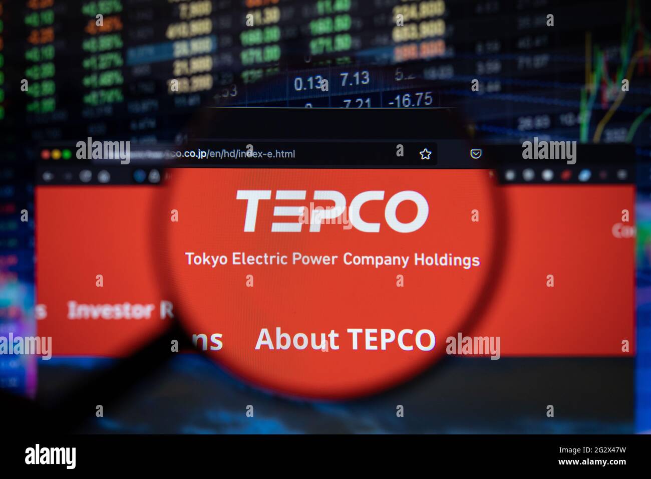 El logotipo de la empresa TEPCO en un sitio web con una evolución borrosa  del mercado de valores en segundo plano, visto en una pantalla de ordenador  a través de una lupa
