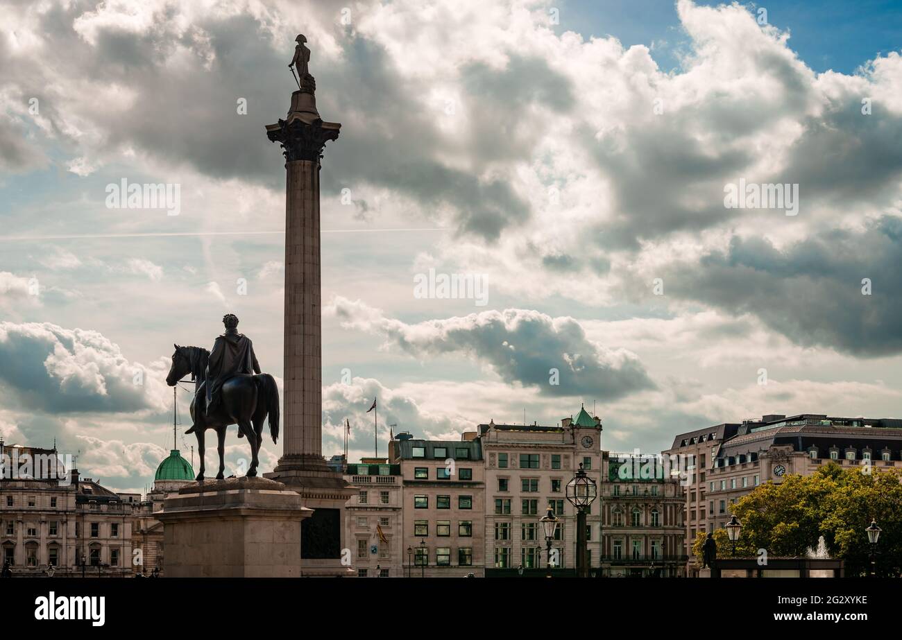 La estatua del rey Jorge IV y la columna de Nelson en Trafalgar Square, en una tarde de otoño. Los edificios de Whitehall están en el fondo. Foto de stock