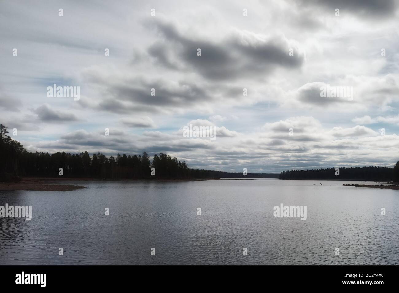 Toma de alto contraste de lago y nubes suecas. Foto de stock
