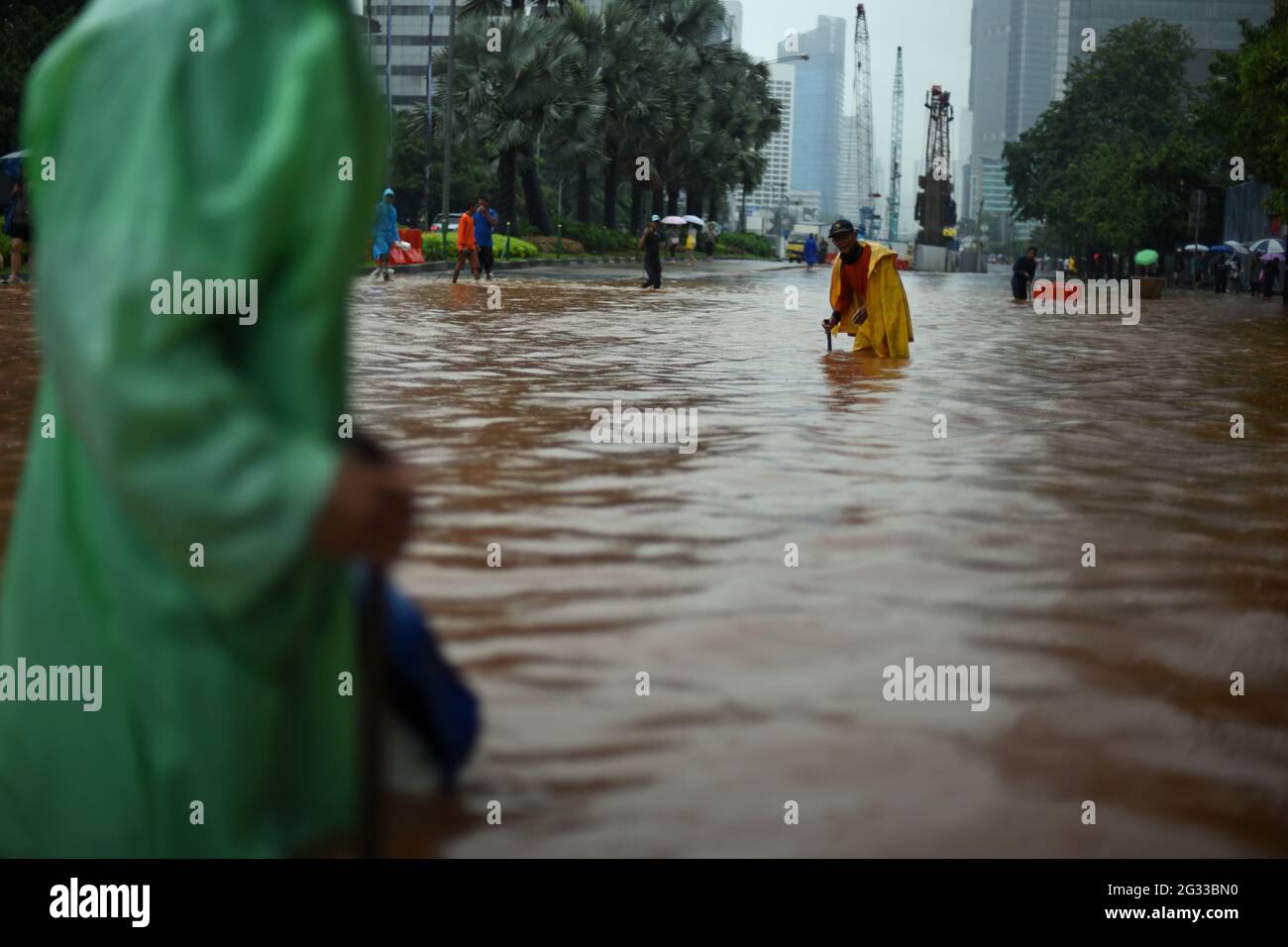 Yakarta, Indonesia. 9th de febrero de 2015. Trabajadores de la oficina de planificación de la ciudad que intentan encontrar si el sistema de drenaje de la calle está obstruido, después de que una lluvia continua dejó Jakarta inundada, en la calle Thamrin que se extiende a través del corazón de la capital de Indonesia. Foto de stock