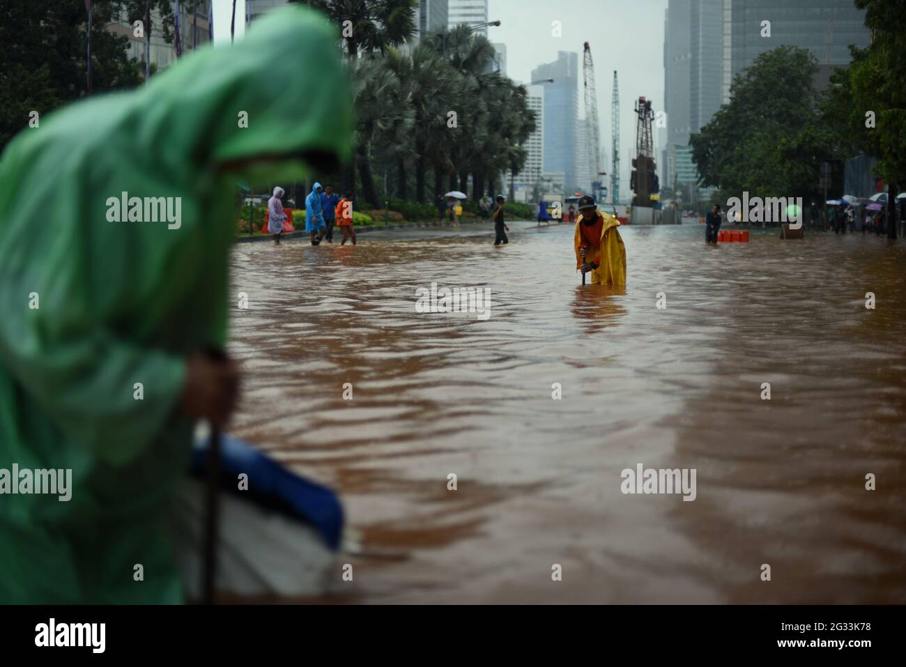 Yakarta, Indonesia. 9th de febrero de 2015. Trabajadores de la oficina de planificación de la ciudad que intentan encontrar si el sistema de drenaje de la calle está obstruido, después de que una lluvia continua dejó Jakarta inundada, en la calle Thamrin que se extiende a través del corazón de la capital de Indonesia. Foto de stock